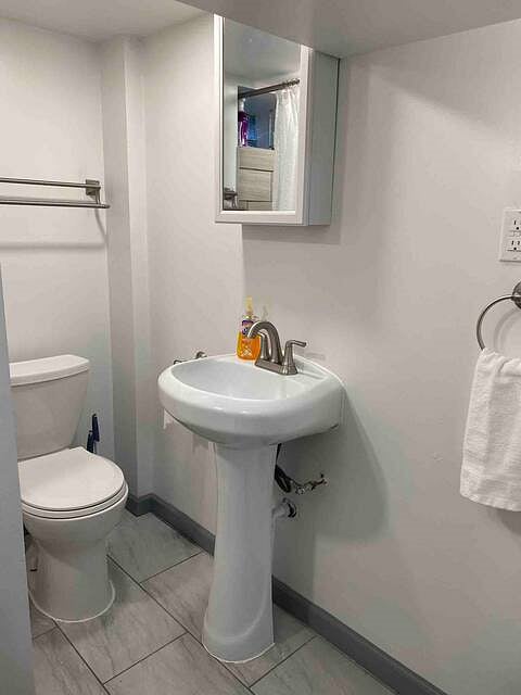 Full bathroom with step in shower located in the basement level of the house