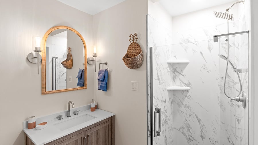 Spa-like bathroom with Quartz walk-in shower, warm wood vanity, and playful pineapple basket accent