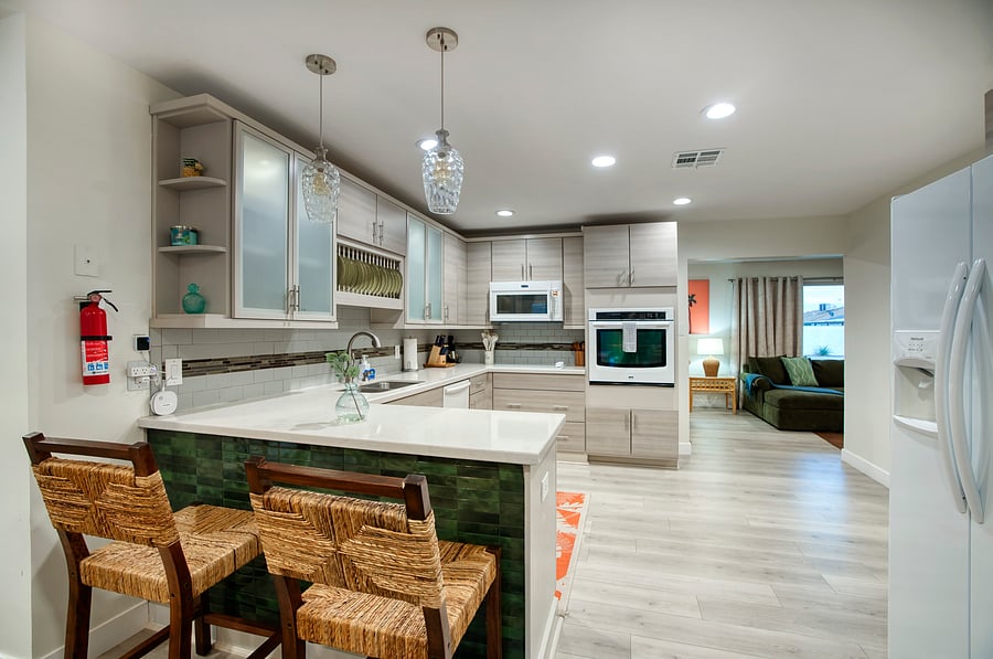 A seamless flow from kitchen to living with mid-century island flair, bamboo bar cart, and warm wood textures