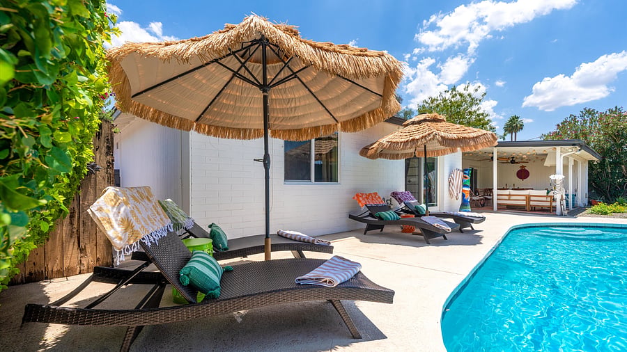Lounge in style beneath tiki umbrellas with plush daybeds and vibrant poolside towels