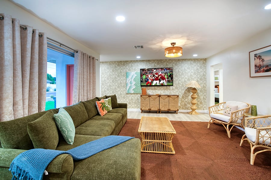 Chic living room with lush sectional, tropical prints, and smart TV for cozy evenings inside