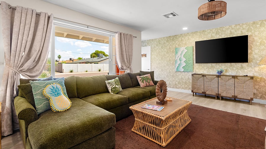 Chic living room with lush sectional, tropical prints, and smart TV for cozy evenings inside
