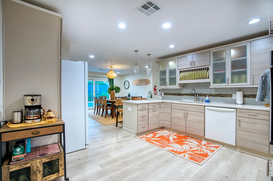 A seamless flow from kitchen to living with mid-century island flair, bamboo bar cart, and warm wood textures