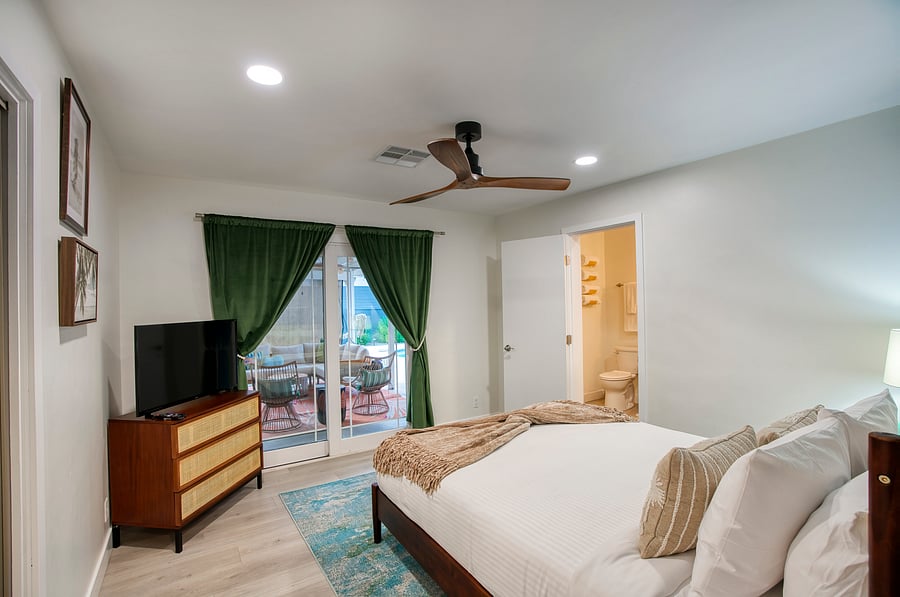 Primary suite with TV and access to patio.