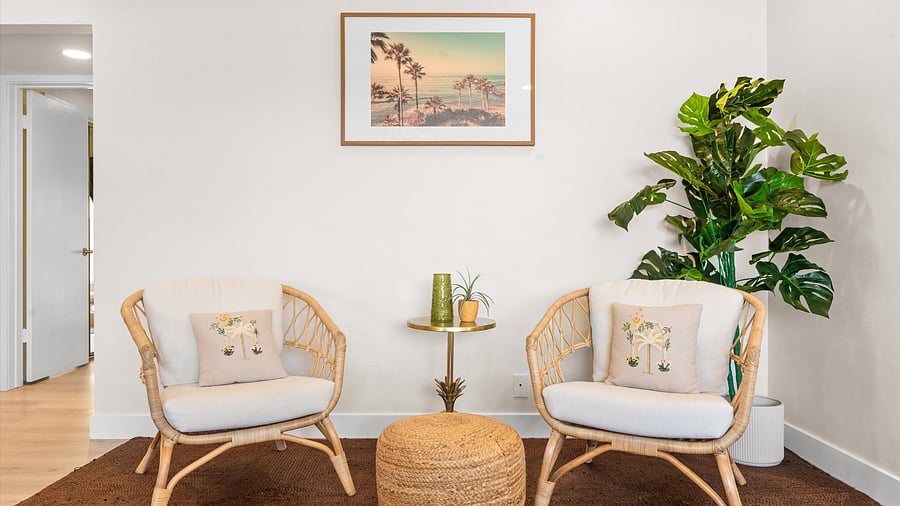 Tropical rattan reading corner with beachy artwork - unwind here with a good book and a cold drink