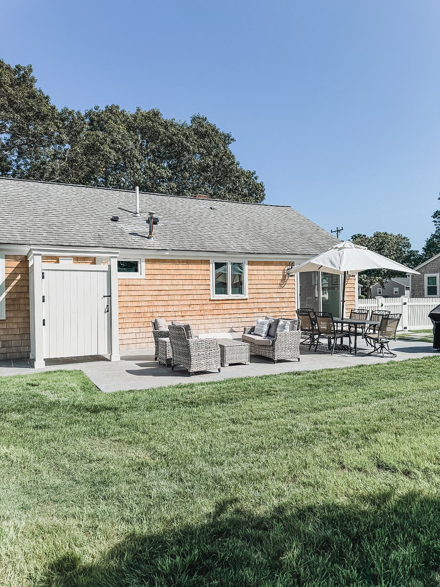 Outdoor living area with dining set, living set, grill and outdoor shower.
