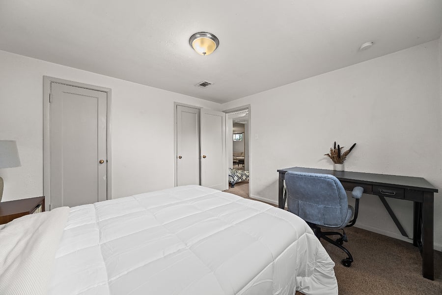 Second bedroom with dedicated work space and closet storage.