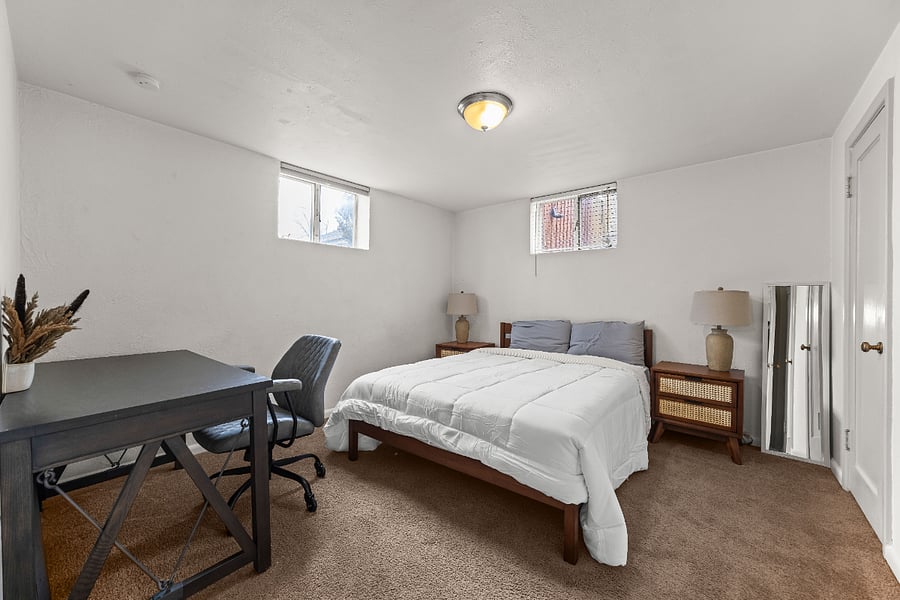Second bedroom with queen bed and dedicated workspace.