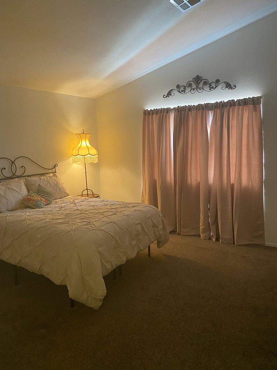 Cream and white bedroom has a more light feminine touch with blackout drapes.