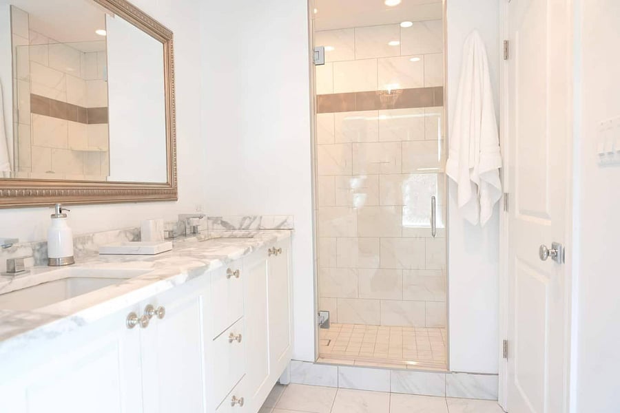 Primary en-suite bathroom with dual sinks and stand up shower