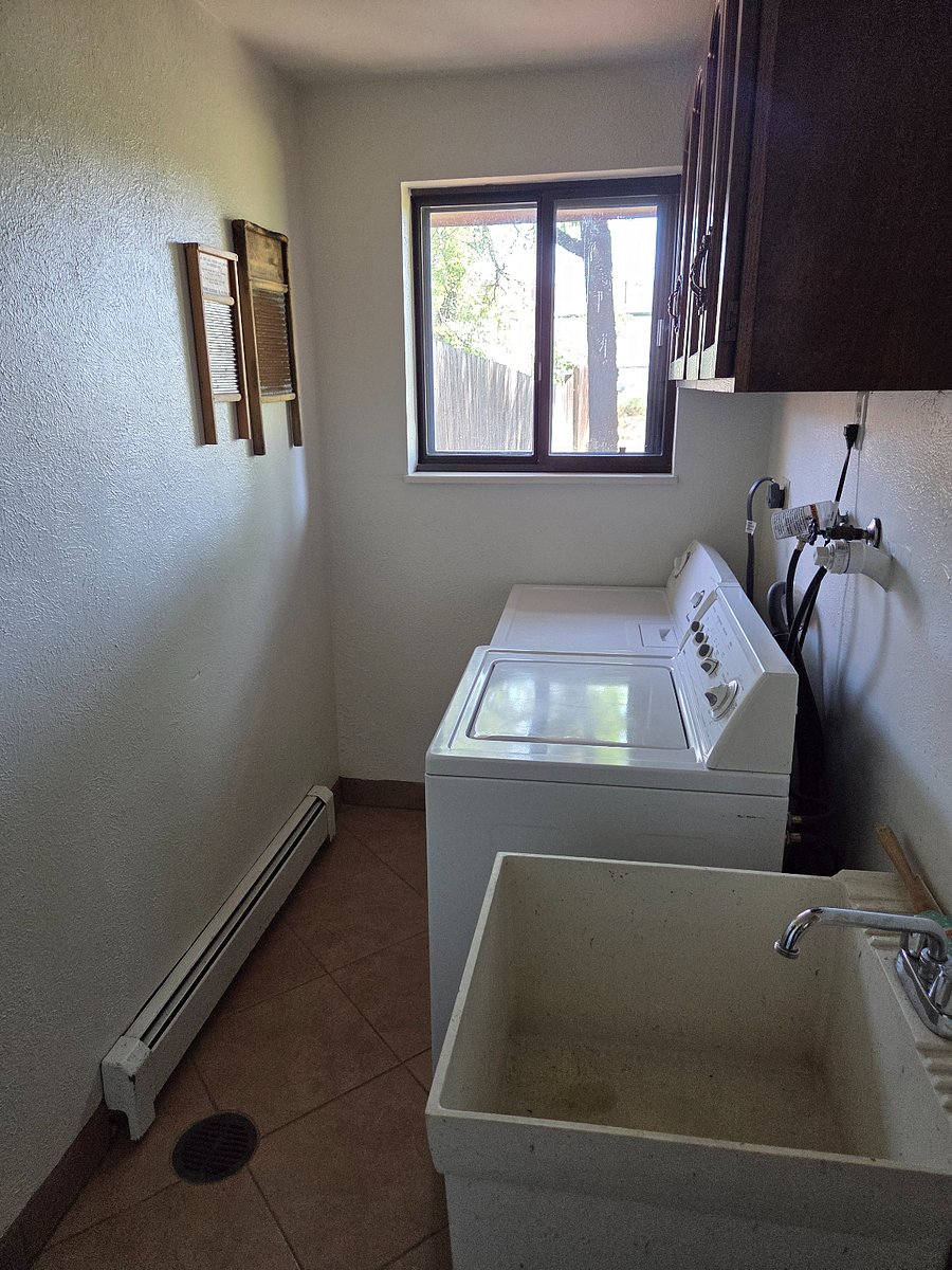 Private laundry room with utility sink on main level
