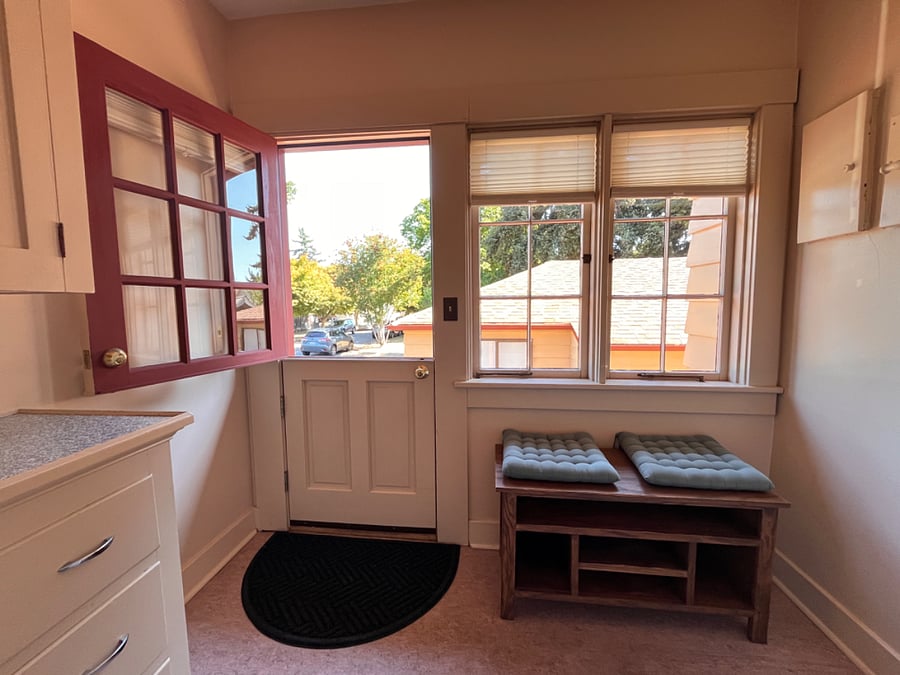 Back entry Dutch door into mudroom with shoe bench and utility storage - "drop zone"