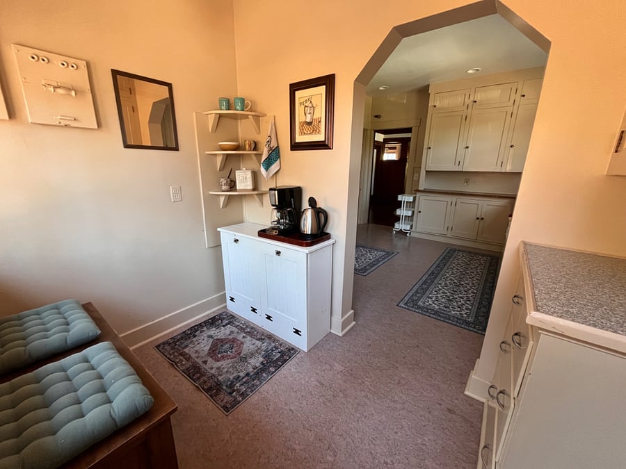 Hidden trash can and recycle cabinet doubles as coffee bar with coffee maker, electric kettle and French press