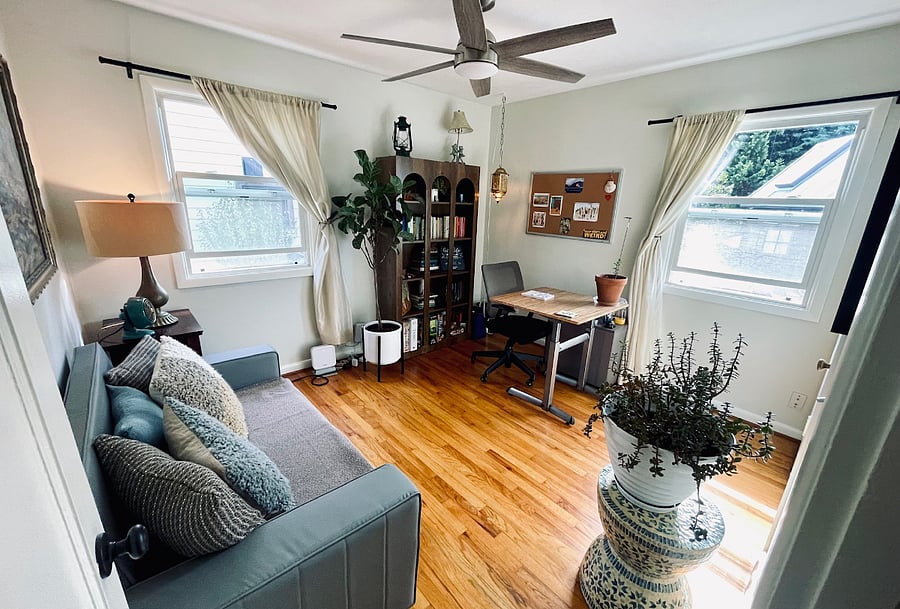 Secondary bedroom set up as a home office with adjustable height desk and rolling office chair