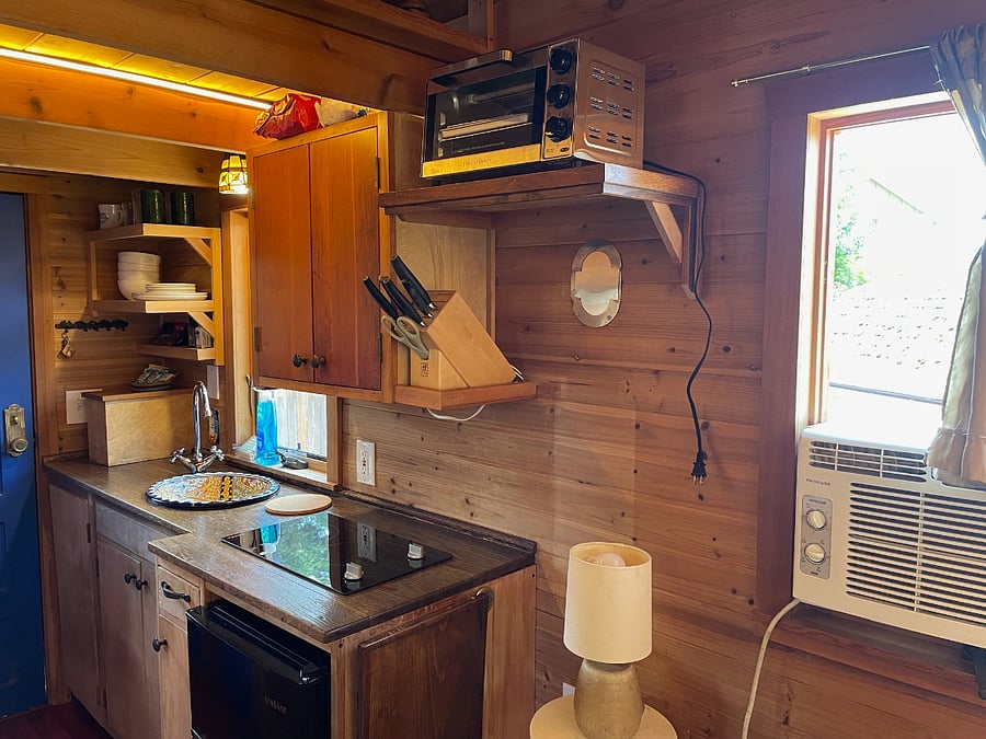 View of kitchen from seating area. AC window unit for summer. Space heater available for winter. Dehumidifier available anytime.