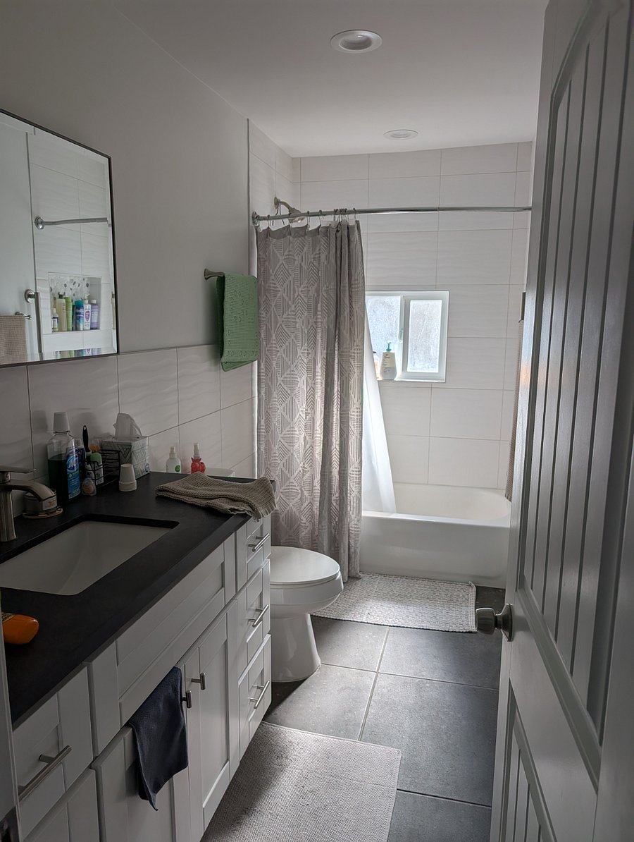 Rental bathroom - has large mirror, partially shown here. One sink, and under sink storage for rental use. Side draws under sink are used by household for medicines, sunscreens, travel size items and first aid.