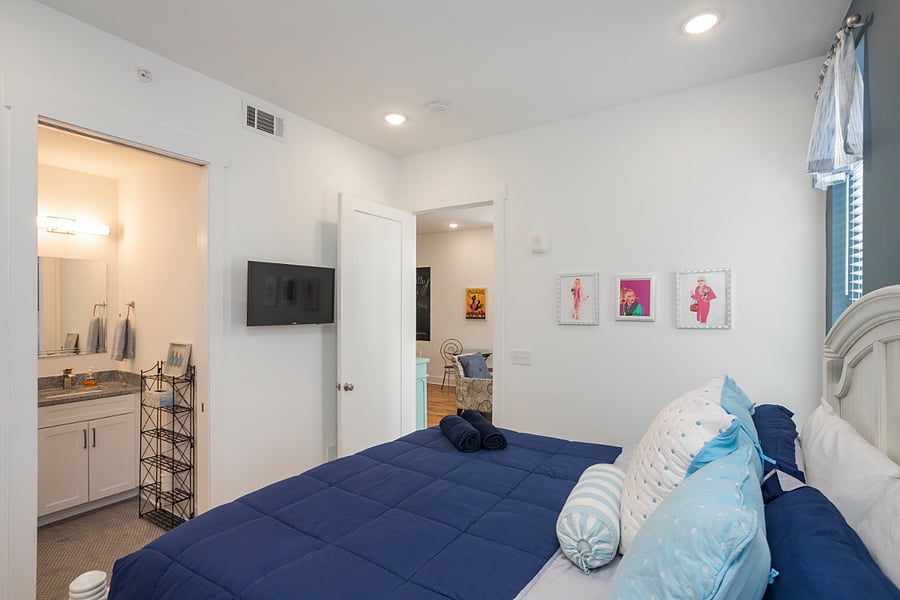 View of bedroom 1 with SMART TV, ensuite bath, opens to open living space.
