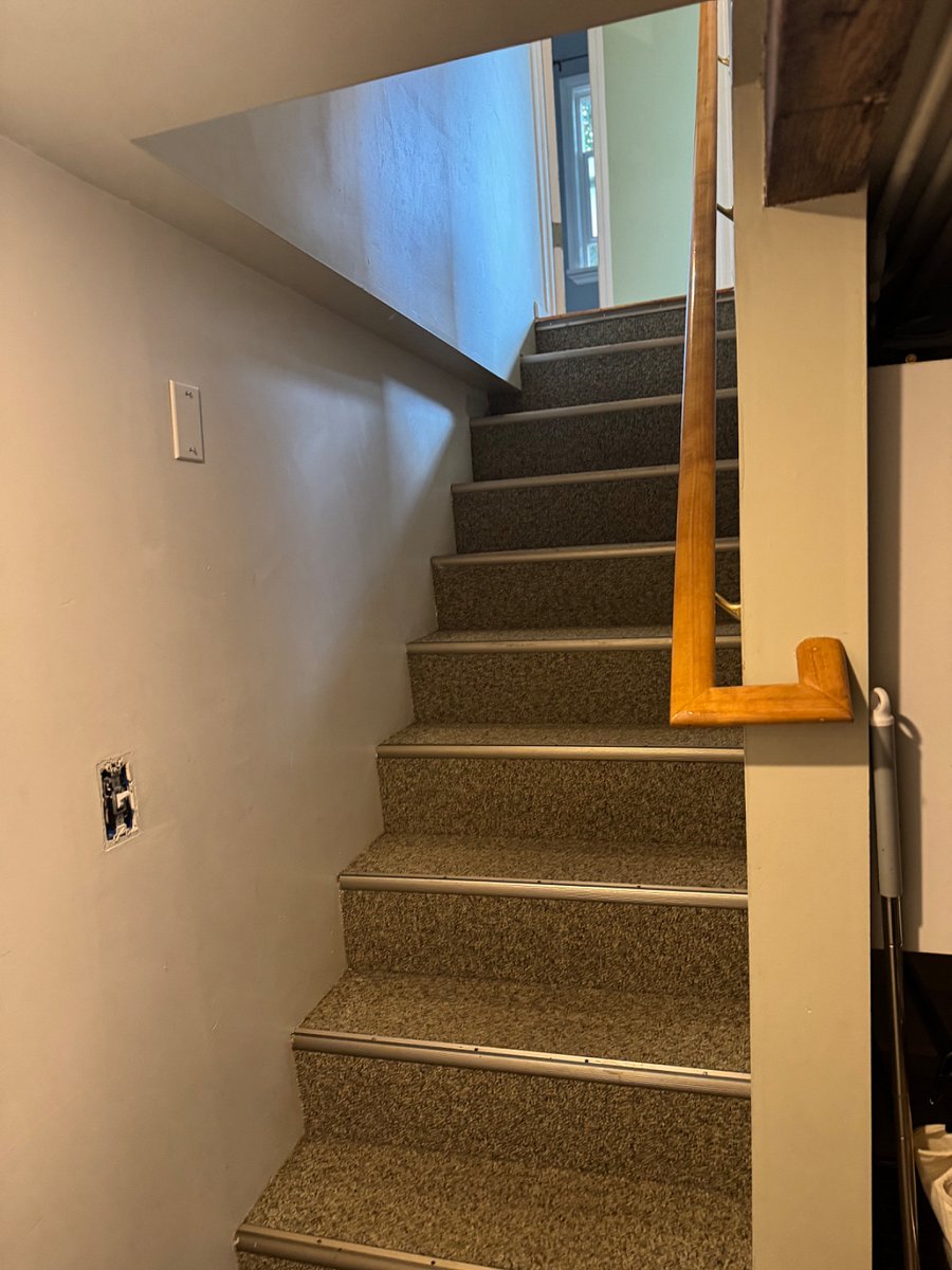 Stairs lead to the lower level where the second bedroom is located.