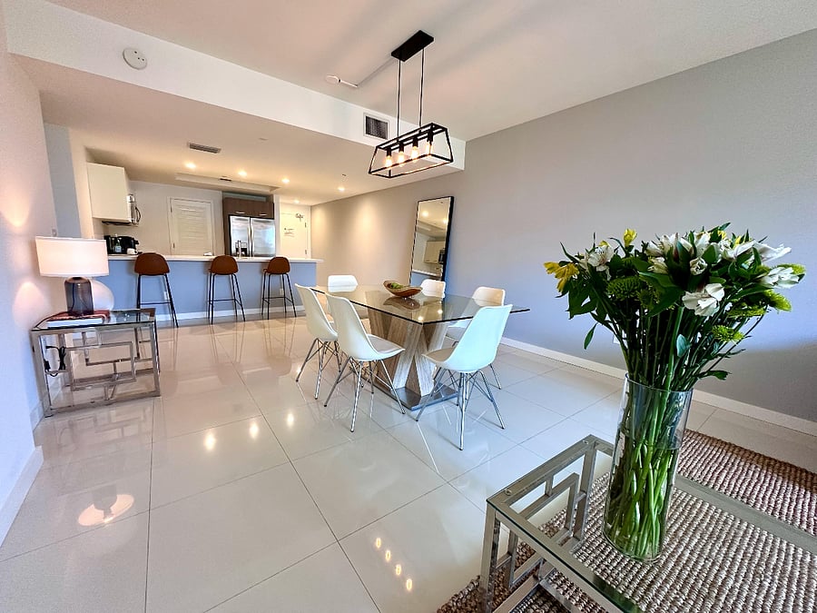 Enjoy a bright, open living room featuring a dining table and a comfortable queen sofa bedideal for relaxing, entertaining, or accommodating extra guests.