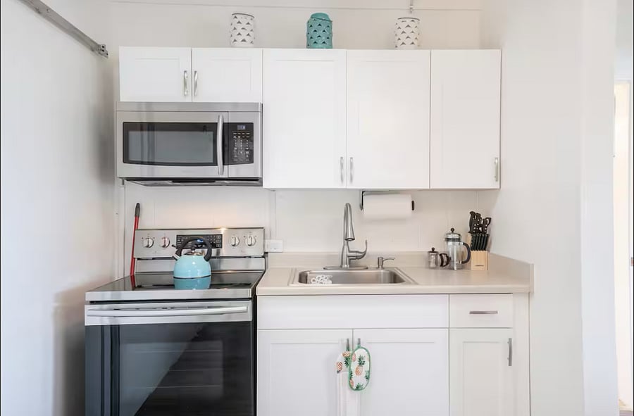Full size kitchen with microwave, stove, oven, coffee maker and full size fridge (not shown on this pic, but located right across this pic). Has basic pots and pans and other cooking utensils, plus plates, glasses and other utensils as well. 