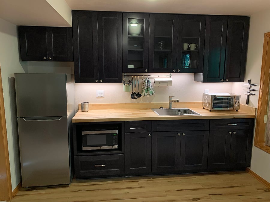 The fully stocked kitchenette is ready for your next meal. A stowed induction cooktop and countertop convection oven cover most needs.