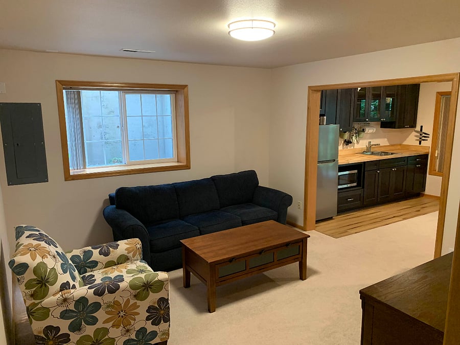 The living room is lit during the day by a south-facing window well.