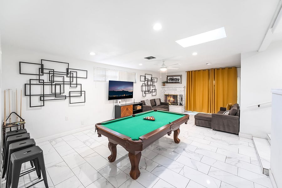 Family room with pool table, fire place, smart tv and sofa beds.