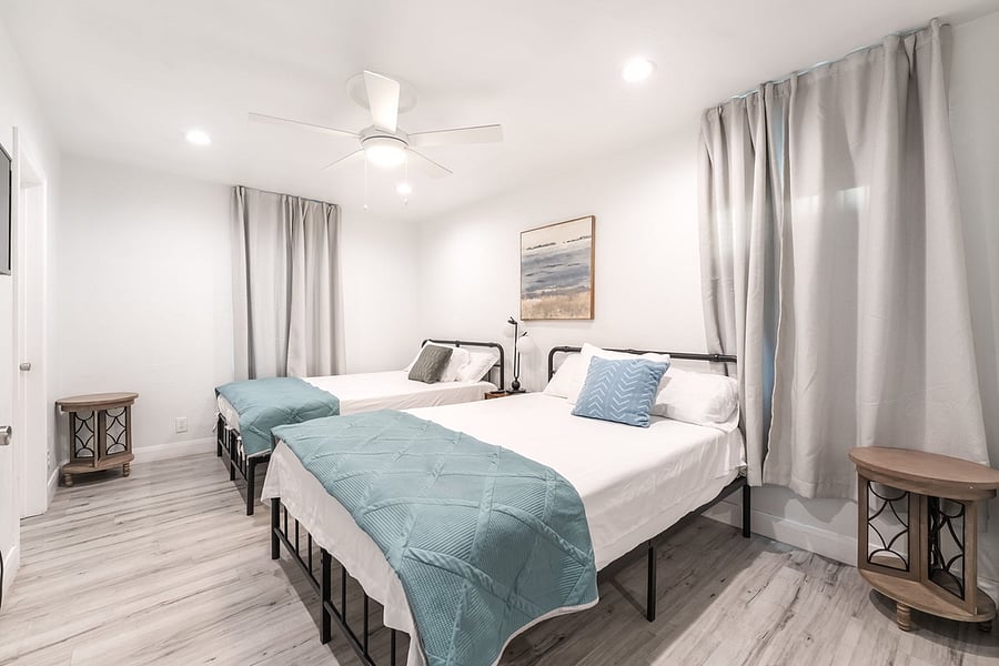 Primary bedroom with two queen beds, connected to full bathroom and his/hers closets and smart tv.