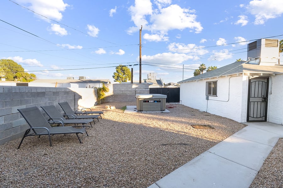 Jacuzzi and lounge chairs in back yard.