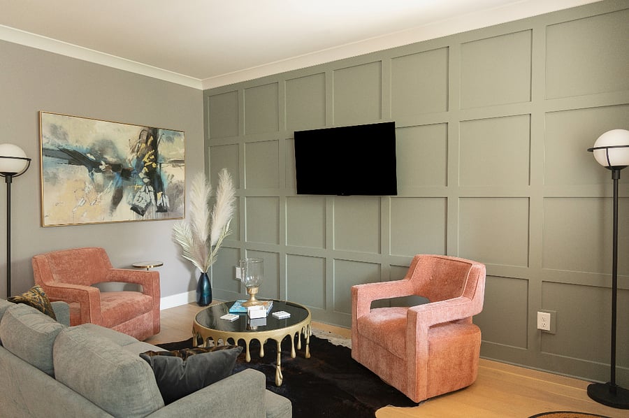 Living room with Smart TV, couch, two swivel chairs, and funky coffee table