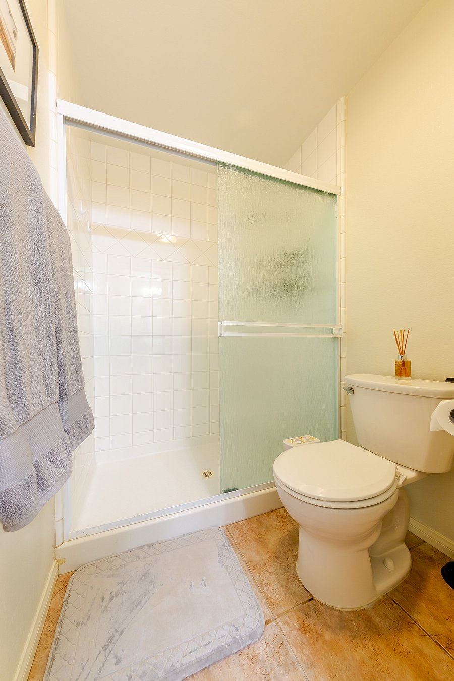 Walk-in tile shower with newer shower head.