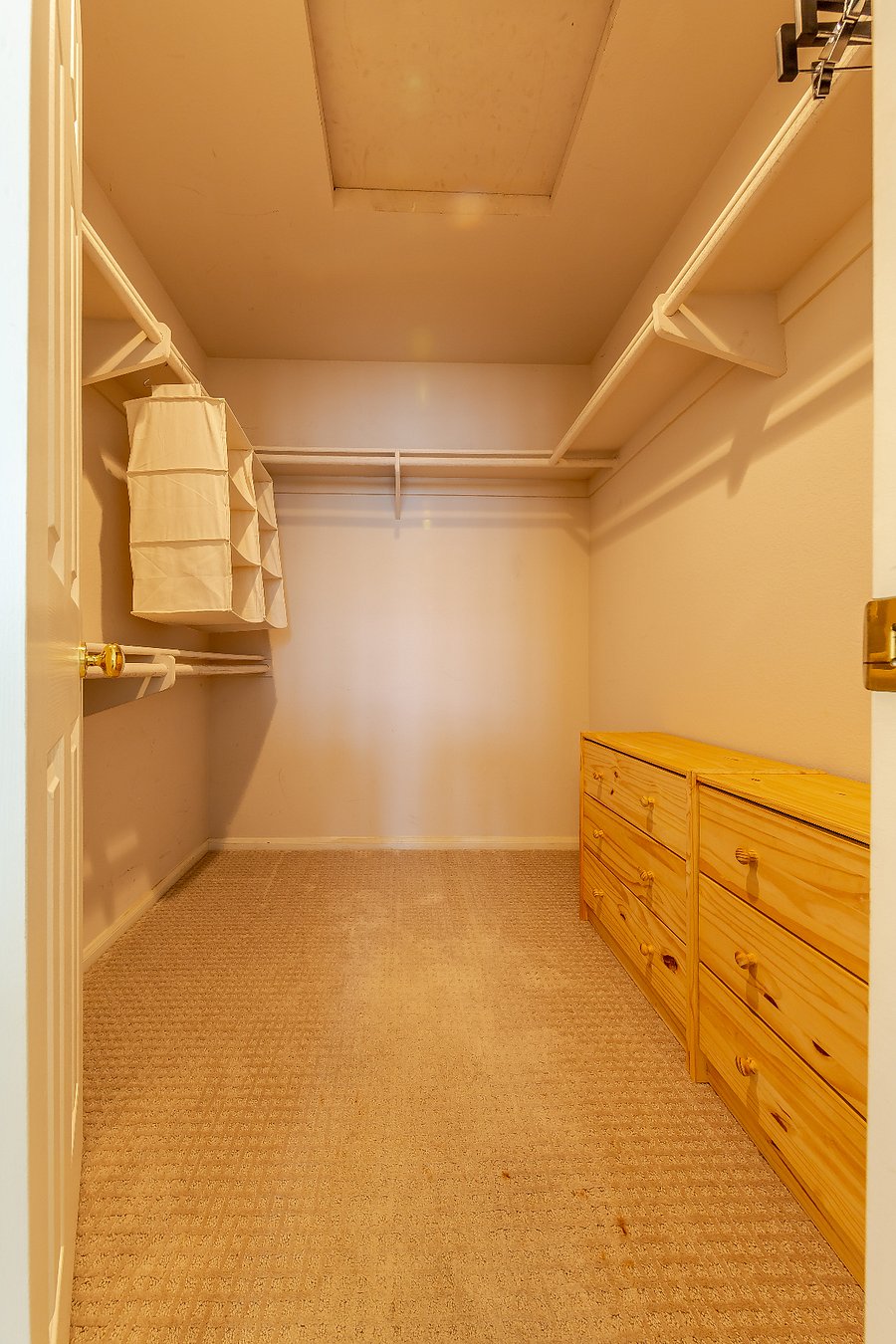 Walk-in closet with drawers and some hanging shelves.