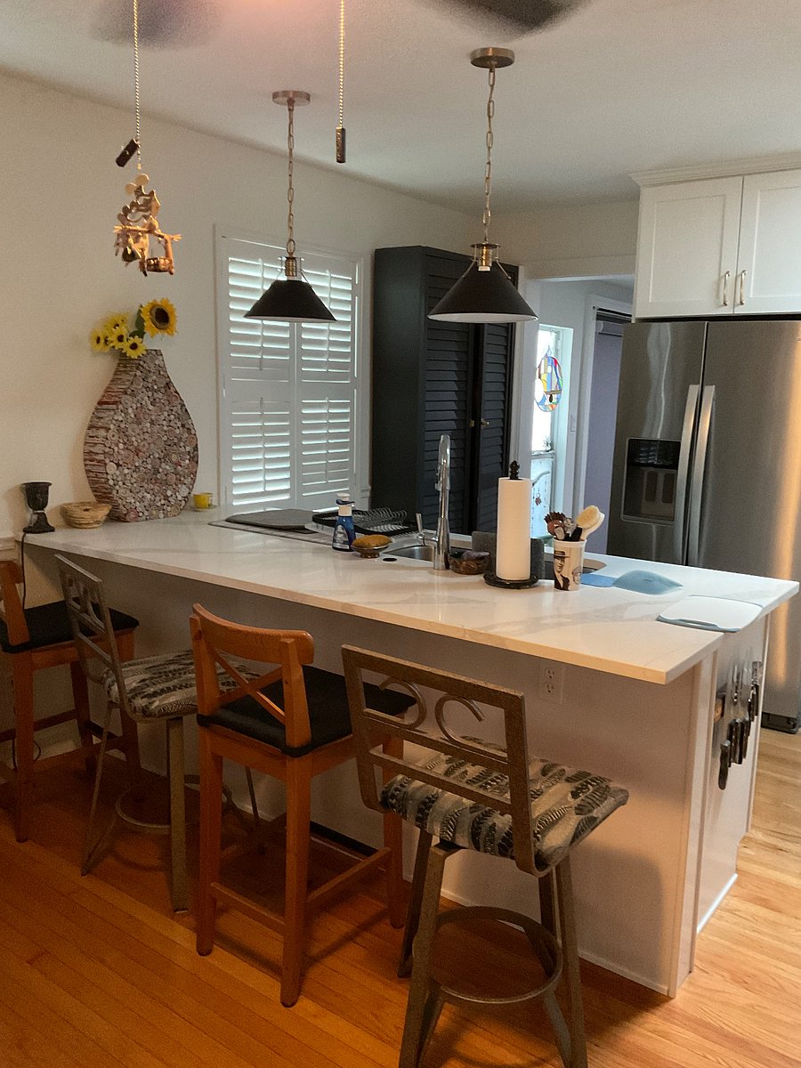 Kitchen eating area with table, 4 chairs and Eating Bar with 2 bar stools.Gray cabinet is food pantry.