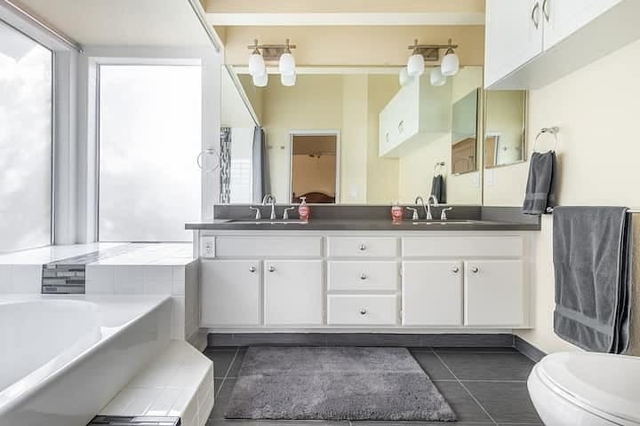 Primary bathroom suite has double sink, a spacious soaking tub / shower with plenty of natural light.