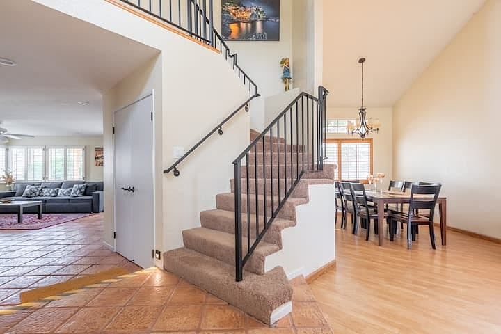 Entrance space leads into both the living room/dining space (on right), upstairs bedrooms, and entertainment / guest bedroom (on left).