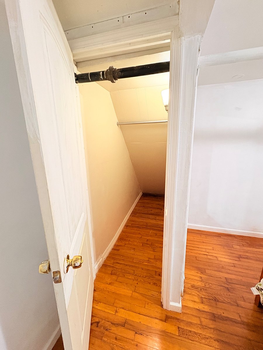 Closet offering convenient additional storage space for clothing, shoes, luggage, and personal belongings. The closet features a built-in hanging rod, wood flooring, and easy access from the bedroom area, making it a practical storage