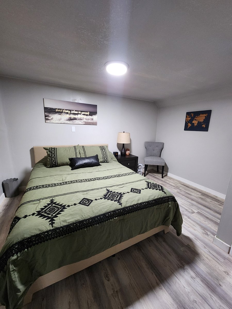 Queen bed. Fan and alarm clock at bedside