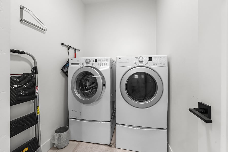Independent laundry room with starter supplies and storage.