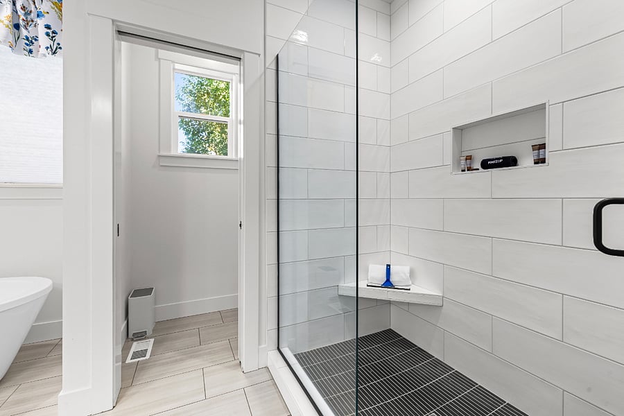 Private water closet and oversize walk-in shower with bench.