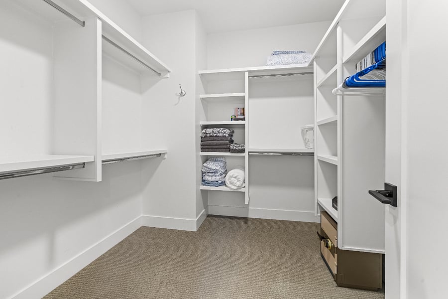 Large walk-in primary closet with plenty of space for all your clothing with multiple racks, shelves and floor space. Some hangers provided.