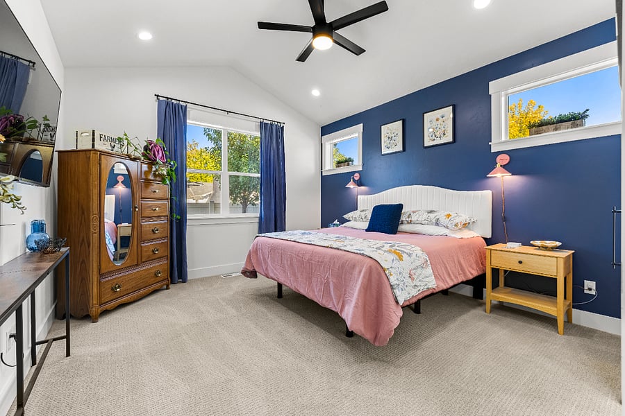 Beautiful primary suite with king bed, large armoire and nightstands for storage.