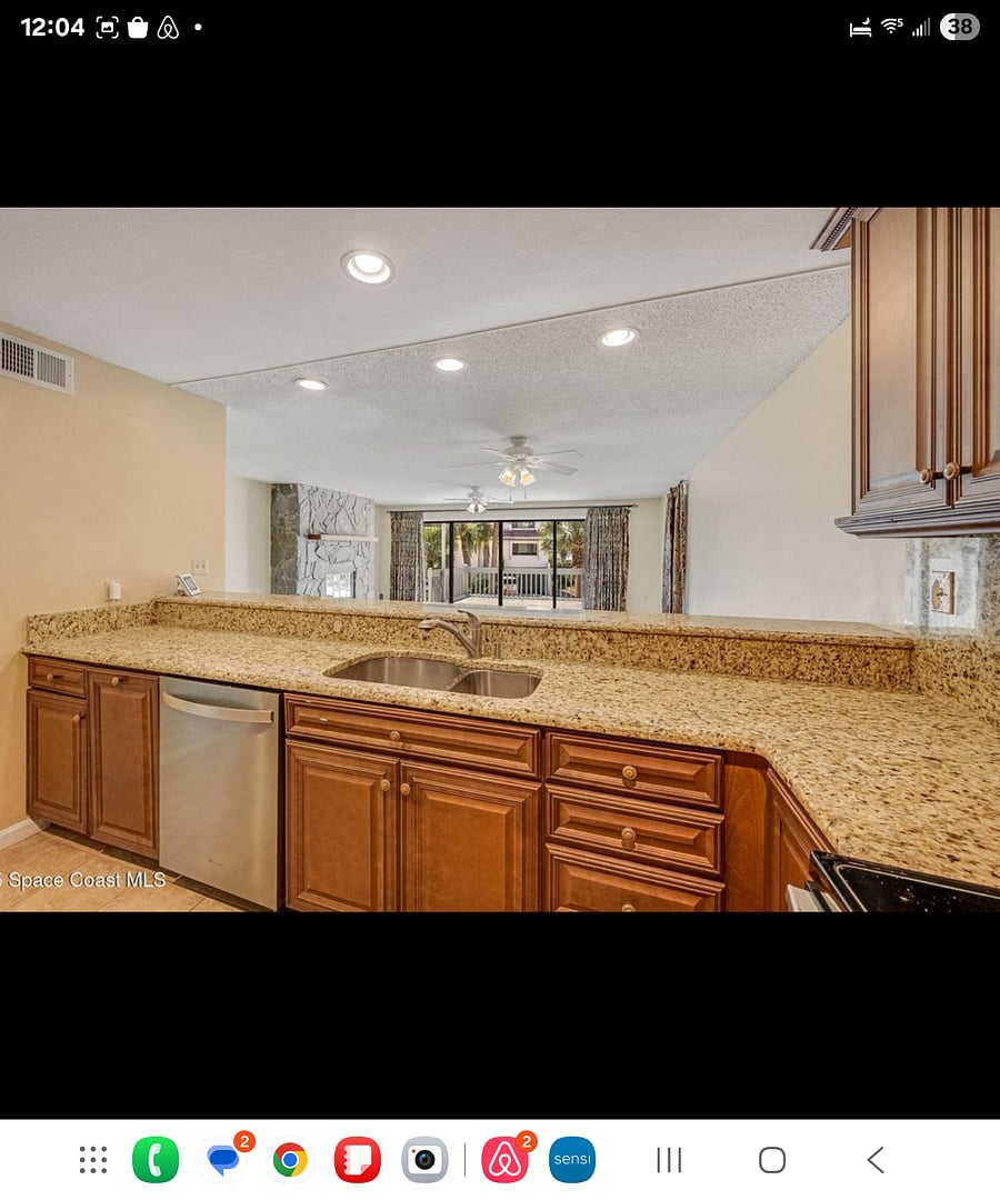 Kitchen overlooks living room. Dishwasher and kitchen sinks.