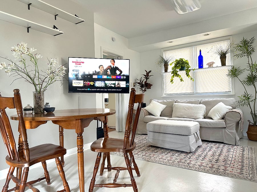 The 43" HiSense Smart TV is on a rotating arm that can move the TV for viewing to either the dining area or the sofa.