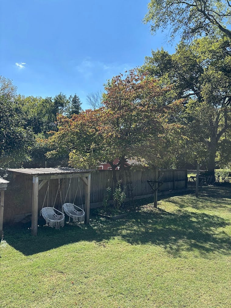 large, fenced yard with swings