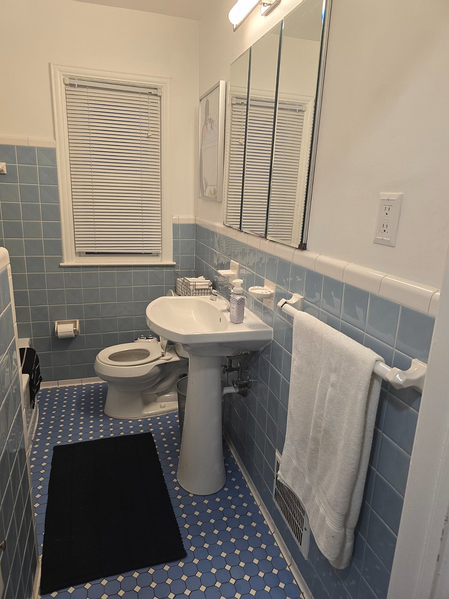 Full bath main floor with closet directly across hall with supplies.
