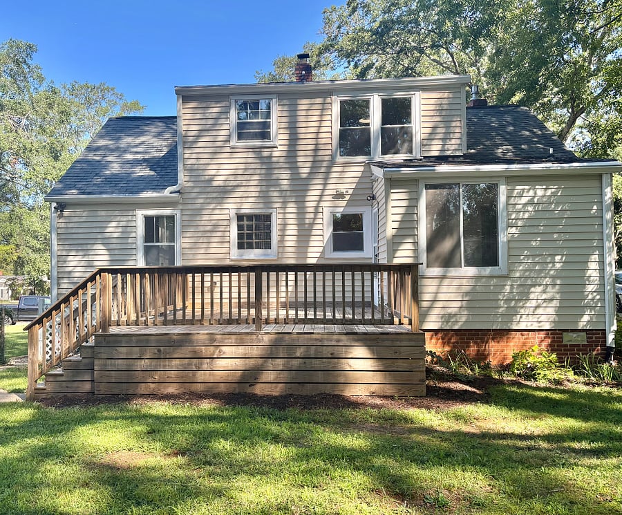 Private backyard with a few chairs on the deck and fenced for dogs and children.2