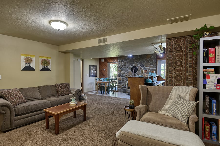 Pull-out sofa sleeper for additional guests, framed by a textured rock wall and rich wood accented with thoughtfully chosen tapestries that elevate the rooms design.