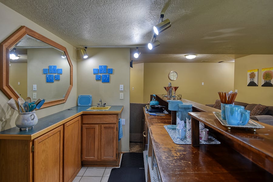 Bright turquoise accents throughout the kitchen add personality and charm, with cupboards fully stocked with coordinating dishes, utensils, and cookware for all your cooking and dining needs.