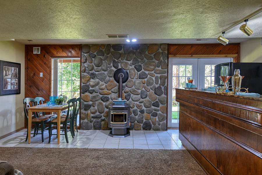 Cozy wood-pellet stove for warmth and ambiance, paired with a restored vintage bar adding character and charm to the kitchen, perfect for coffee, cocktails, or extra prep space.