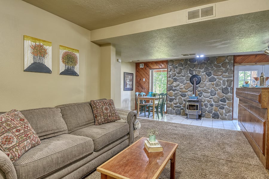 Cozy living area with pellet stove, comfortable seating, and upscale Sackcloth and Ashes throws throughout.
